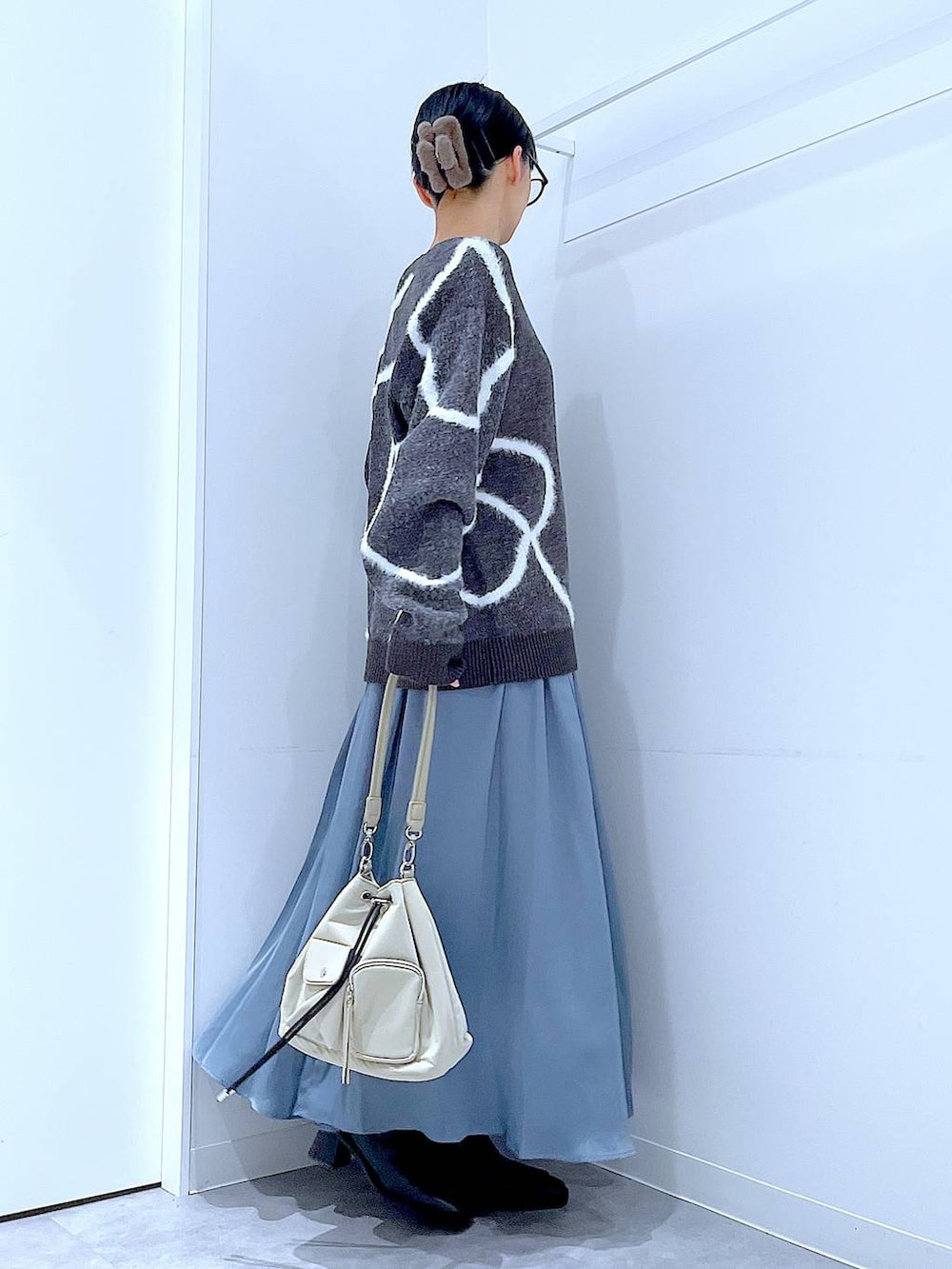 ブラック系のブーツ、グレー系のニット/セーター、ブラウン系のバレッタ/ヘアクリップを着用したレディースの冬コーディネートの4枚目の写真