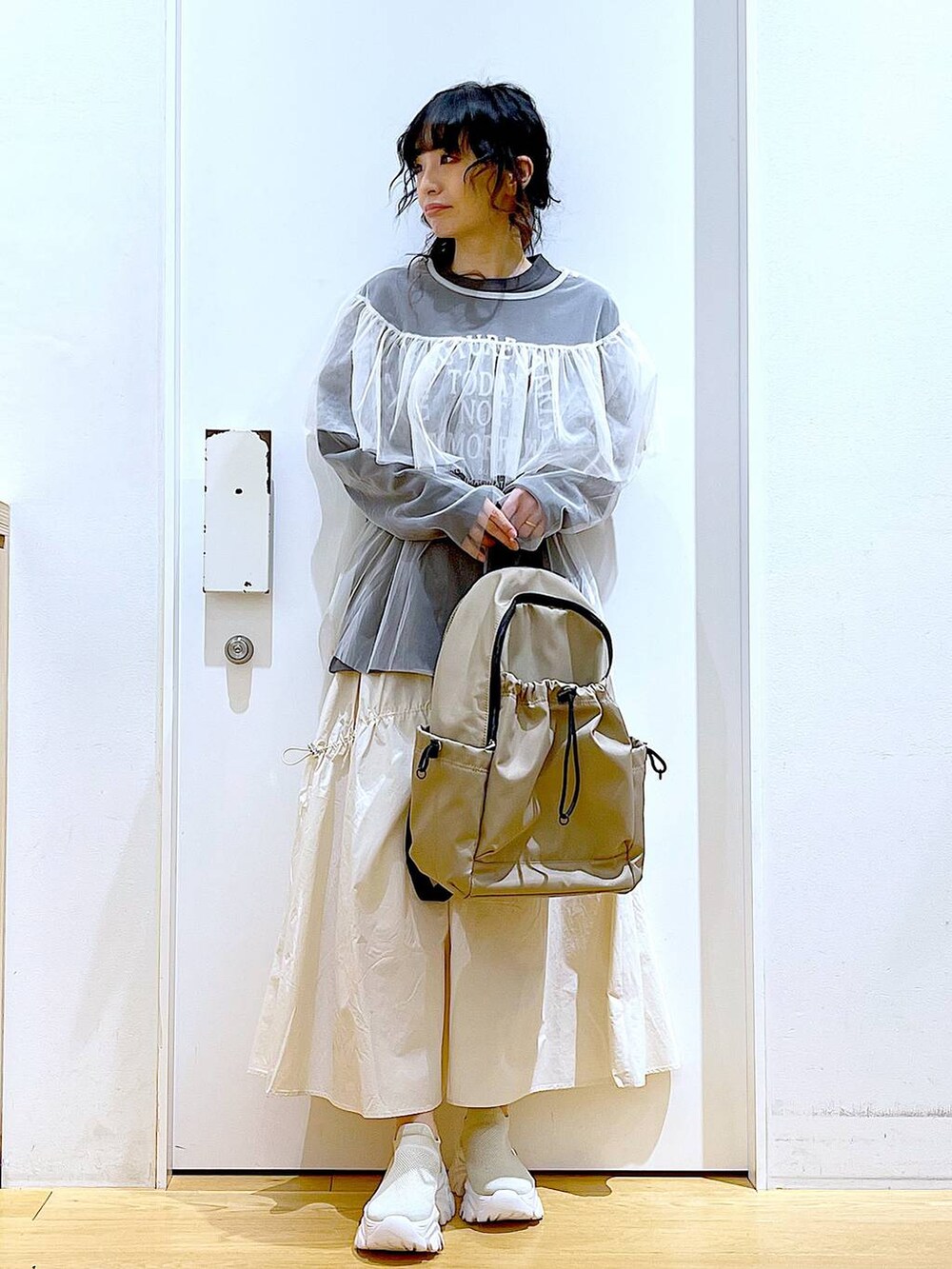 ベージュ系のスニーカー、ホワイト系のその他トップス、ホワイト系のスカートを着用したレディースの春コーディネートの2枚目の写真