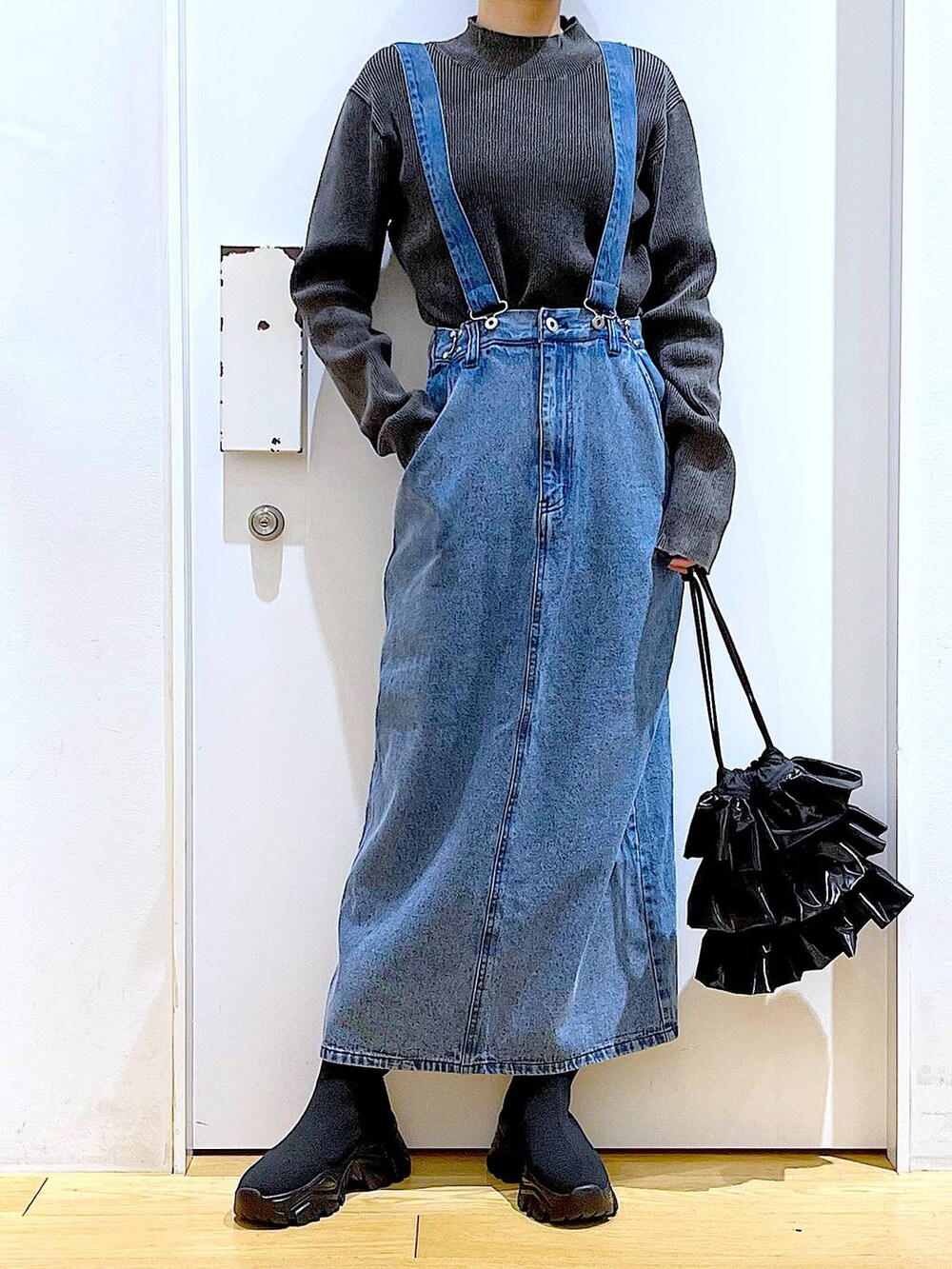 ブラック系のブーツ、ブラック系のショルダーバッグ、ブラック系のニット/セーターを着用したレディースの春コーディネートの6枚目の写真