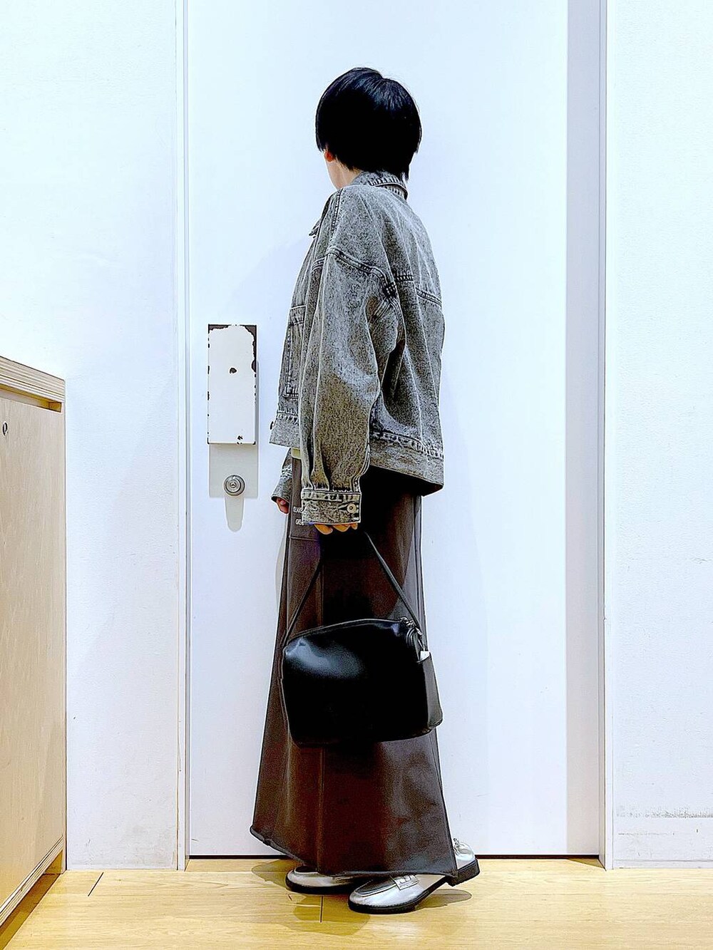 ブラック系のショルダーバッグ、シルバー系のローファー、ブラック系のデニムジャケットを着用したレディースの春コーディネートの3枚目の写真