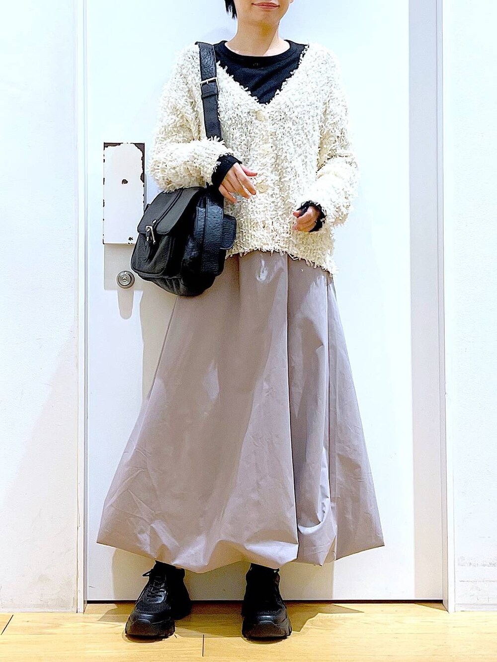 ブラック系のスニーカー、ブラック系のTシャツ/カットソー、グレー系のスカートを着用したレディースの春コーディネートの6枚目の写真