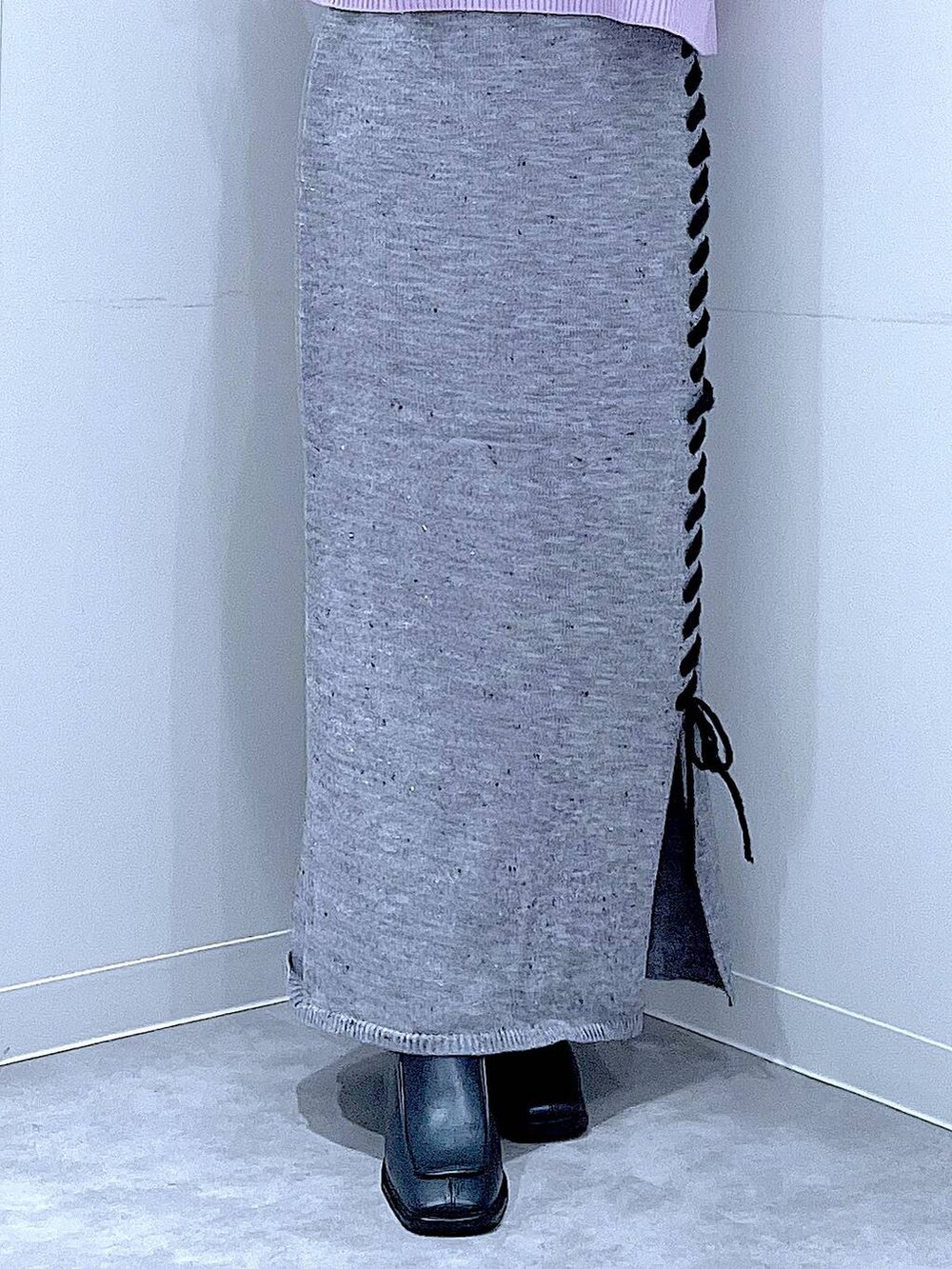 ブラック系のボストンバッグ、グレー系のスカート、ブラック系のブーツを着用したレディースの冬コーディネートの8枚目の写真