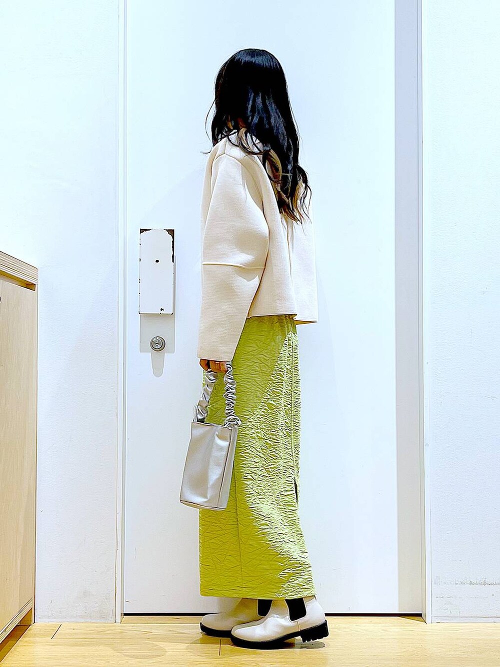 その他のショルダーバッグ、グリーン系のスカート、ベージュ系のブーツを着用したレディースの春コーディネートの3枚目の写真