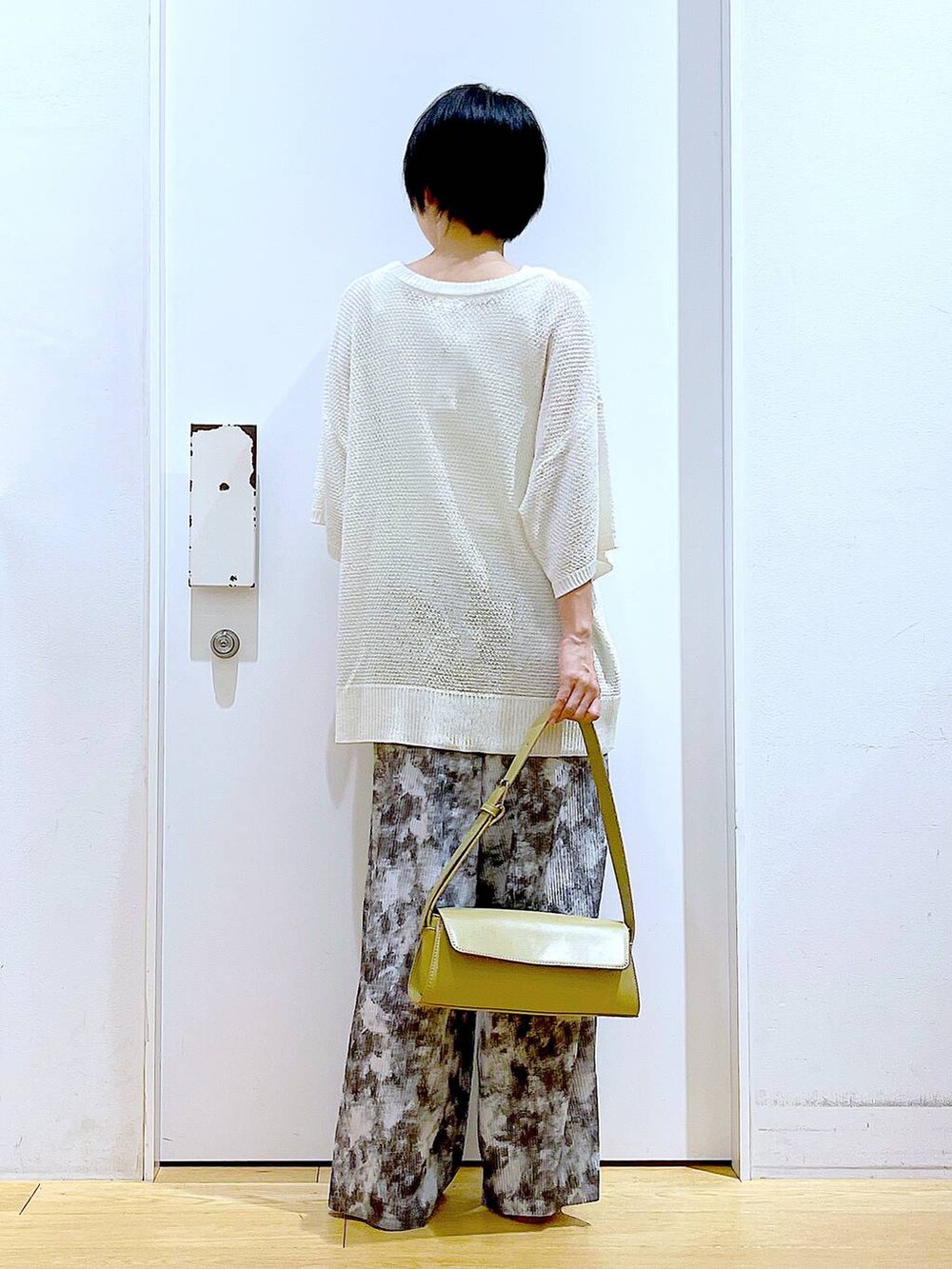 ベージュ系のパンプス、イエロー系のショルダーバッグ、グレー系のその他パンツを着用したレディースの春コーディネートの5枚目の写真