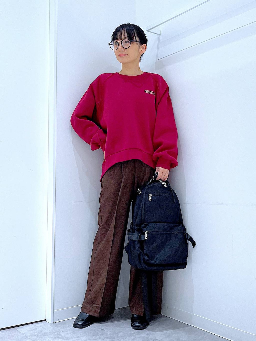 ブラック系のブーツ、ブラウン系のスラックス、ブラック系のバックパック/リュックを着用したレディースの冬コーディネートの2枚目の写真