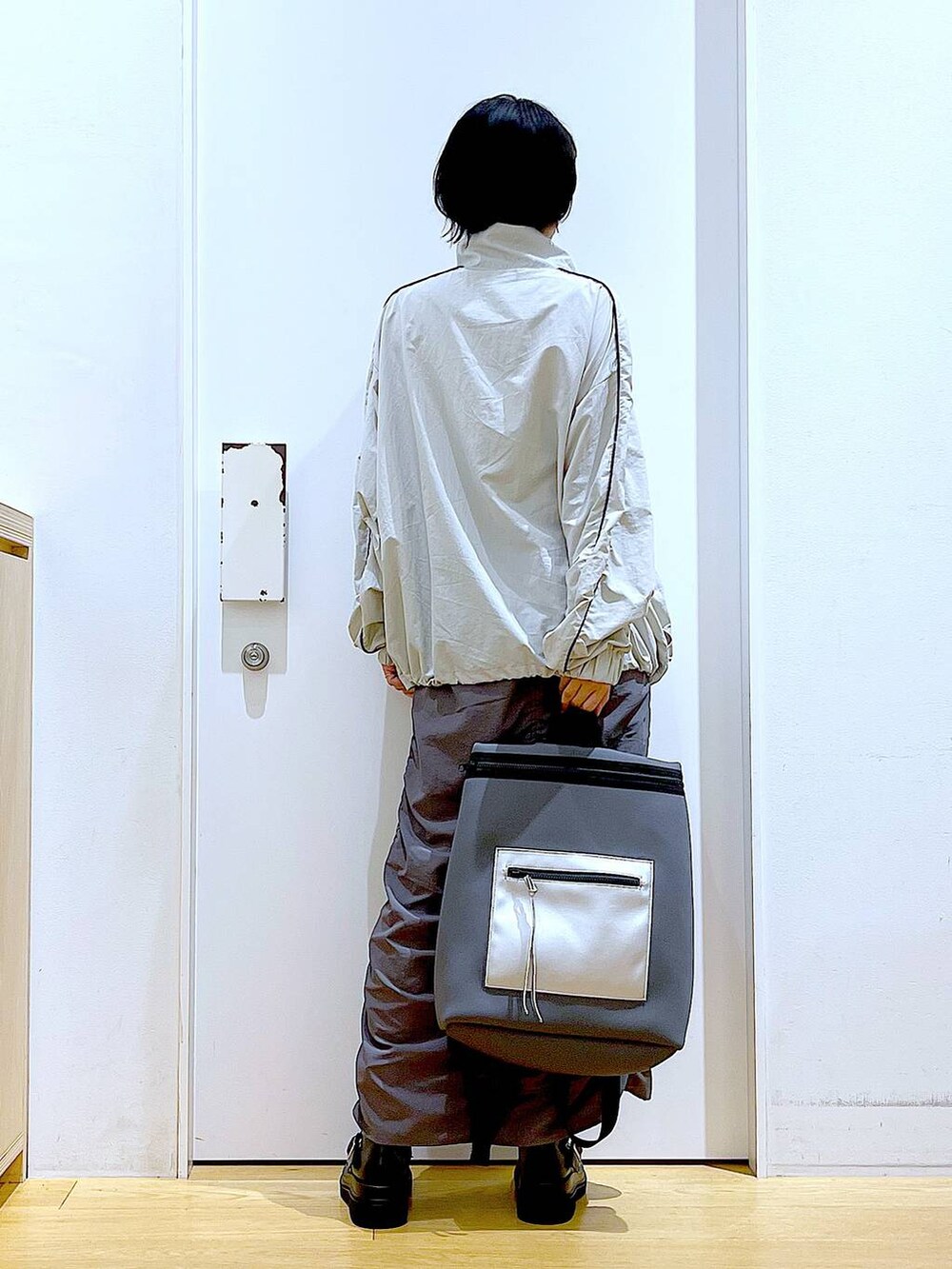 ブラック系のブーツ、グレー系のバックパック/リュック、グレー系のブルゾンを着用したレディースの秋コーディネートの5枚目の写真