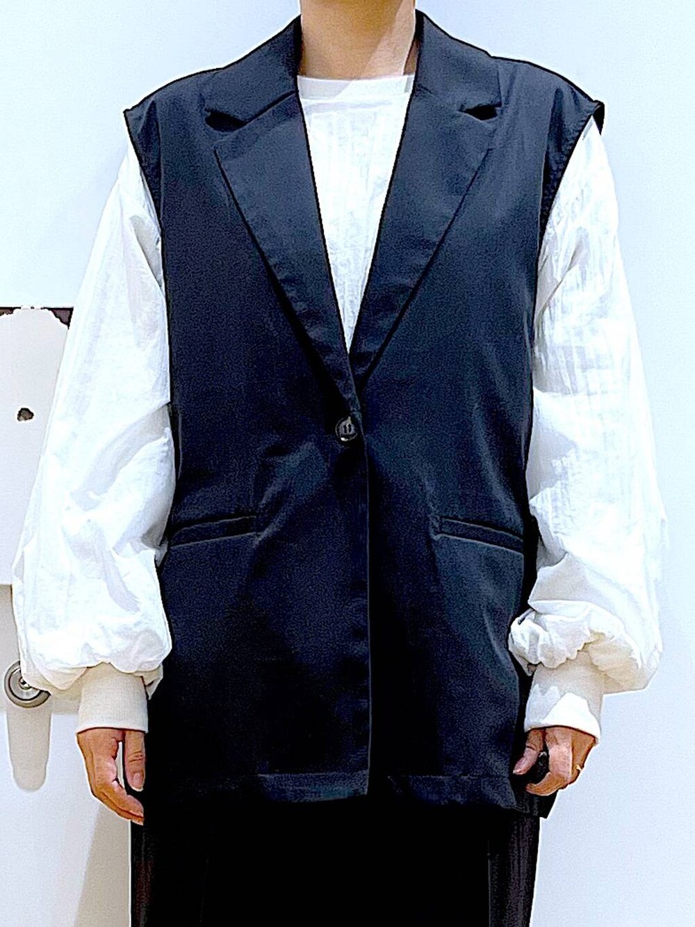 ブラック系のスラックス、ブラック系のパンプス、ホワイト系のスウェットを着用したレディースの春コーディネートの7枚目の写真