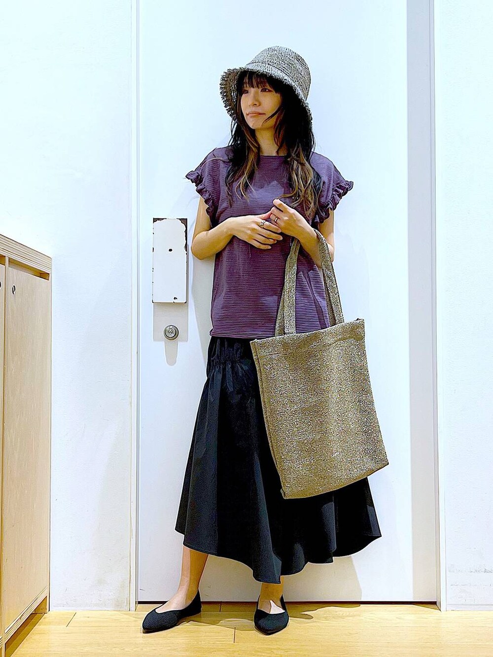 ブラック系のパンプス、ブラウン系のTシャツ/カットソー、ブラック系のスカートを着用したレディースの夏コーディネートの2枚目の写真