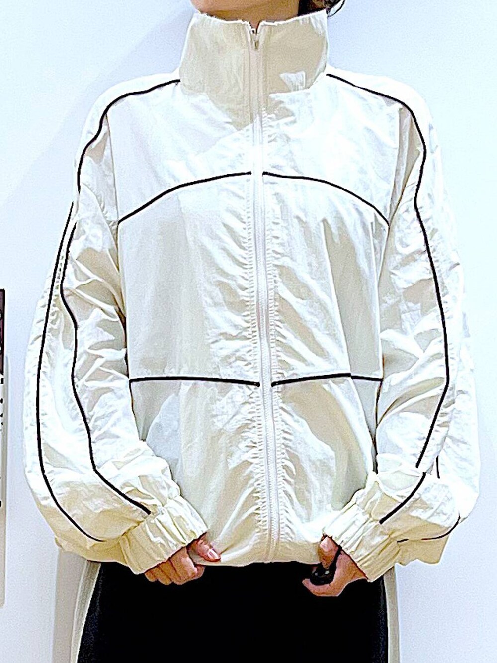 ブラック系のスカート、ベージュ系のブルゾン、グレー系のショルダーバッグを着用したレディースの秋コーディネートの7枚目の写真