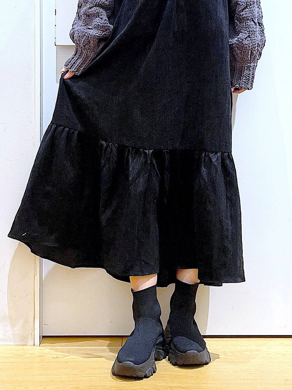 シルバー系のトートバッグ、ブラック系のブーツ、グレー系のニット/セーターを着用したレディースの冬コーディネートの8枚目の写真