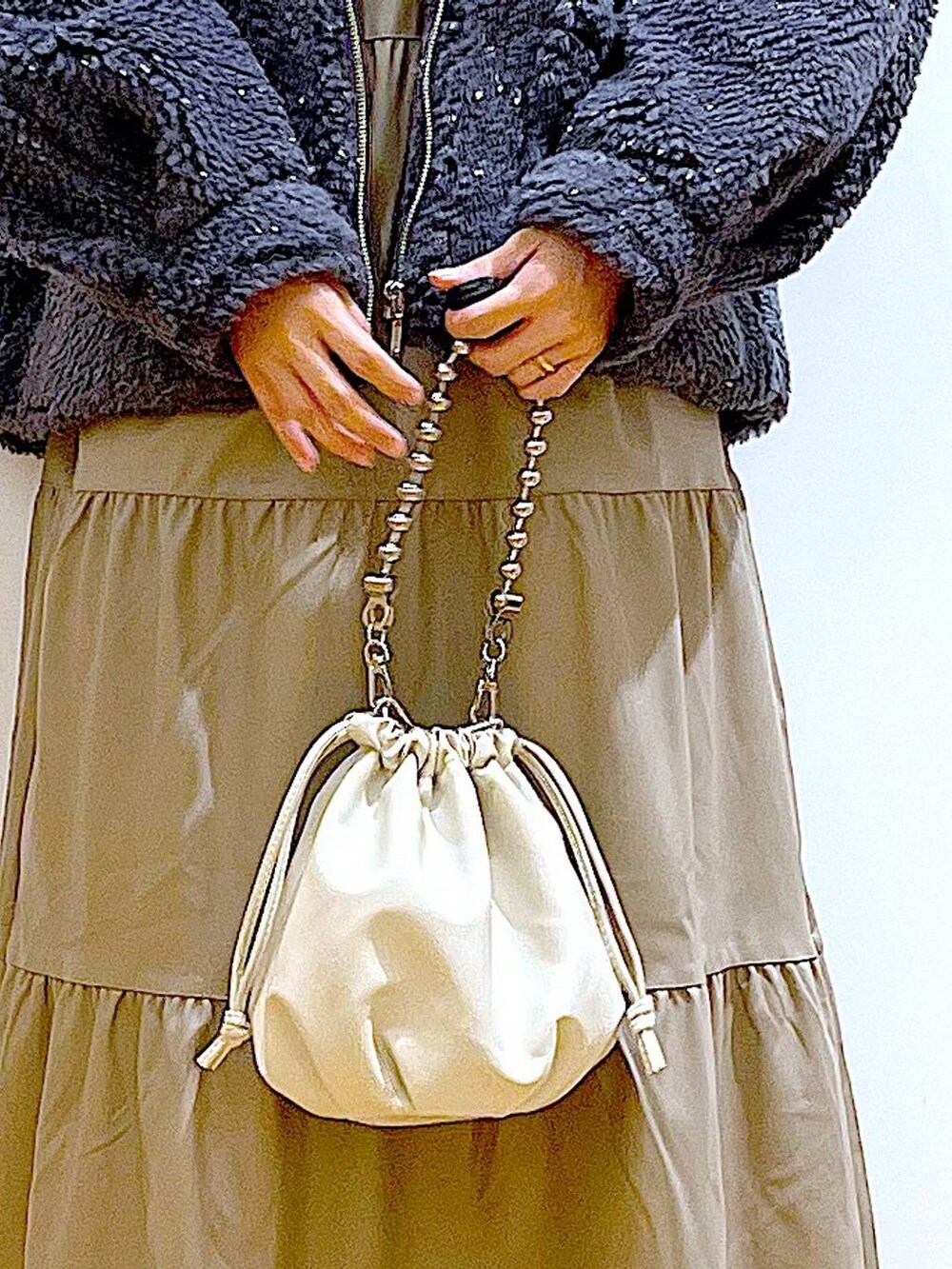 ベージュ系のショルダーバッグ、ブラック系のブーツ、ブラウン系のワンピースを着用したレディースの冬コーディネートの9枚目の写真