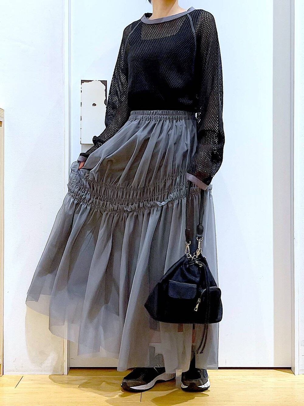 ブラック系のTシャツ/カットソー、グレー系のスカートを着用したレディースの春コーディネートの6枚目の写真