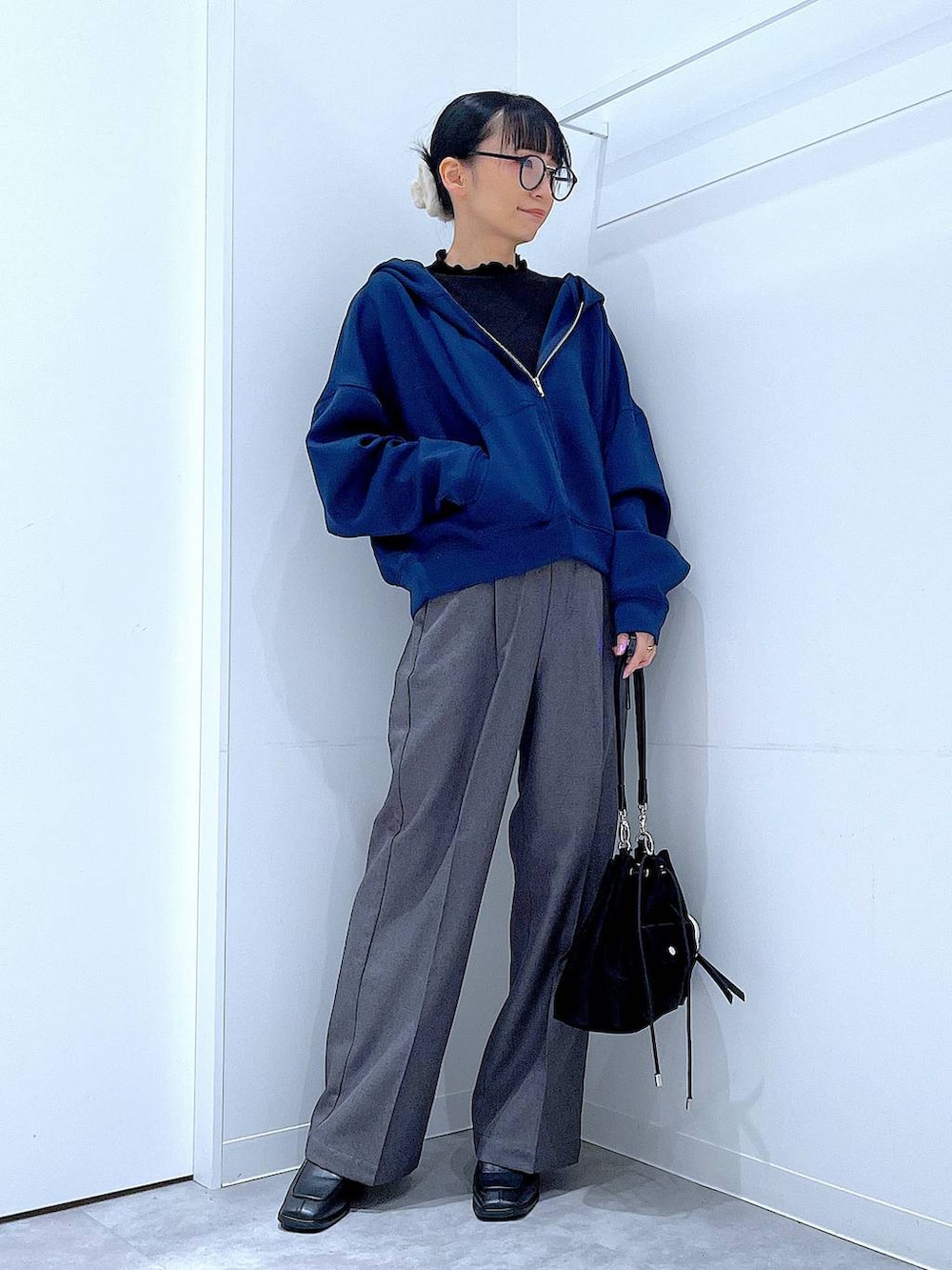 ブラック系のショルダーバッグ、ブラック系のブーツ、グレー系のスラックスを着用したレディースの冬コーディネートの2枚目の写真