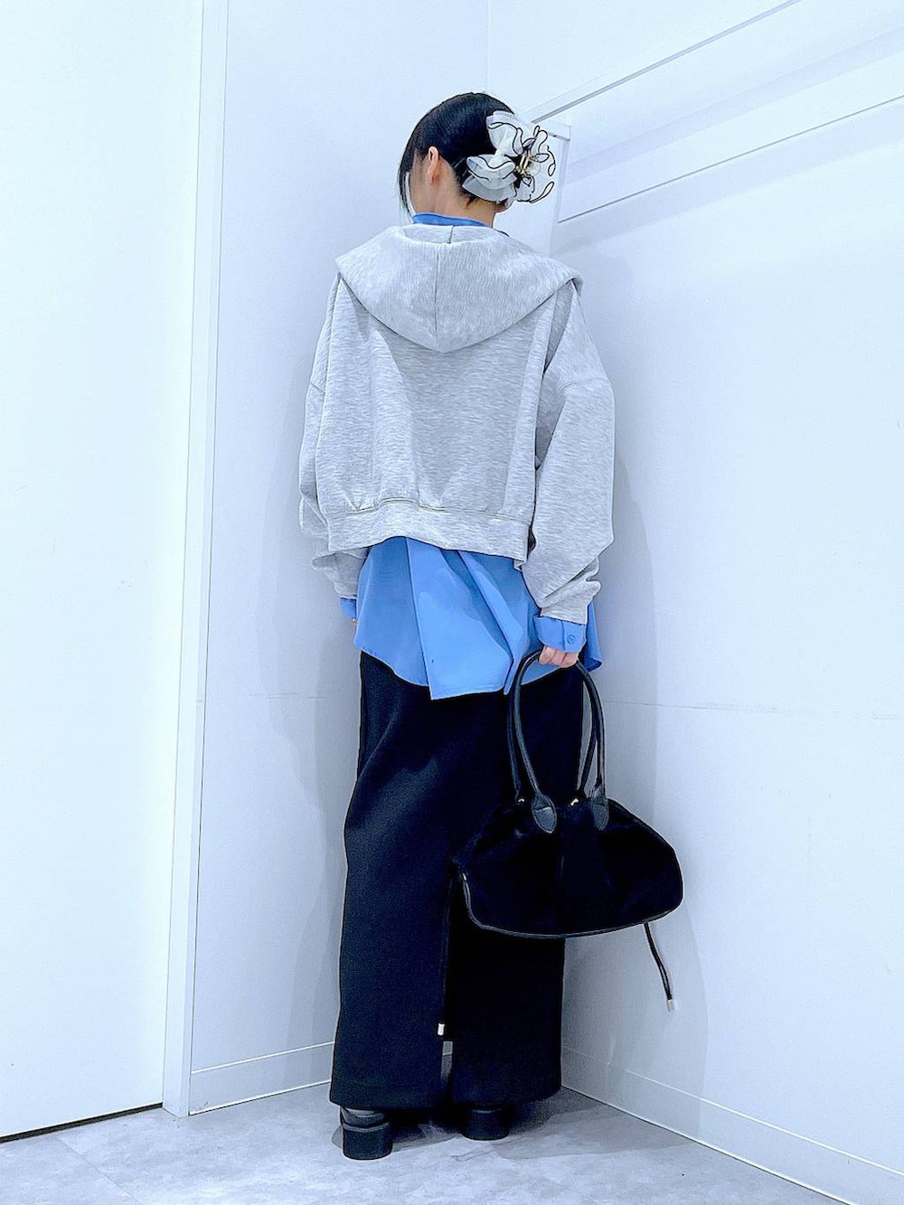 ブラック系のハンドバッグ、ブラック系のスカート、ブラック系のサンダルを着用したレディースの冬コーディネートの5枚目の写真