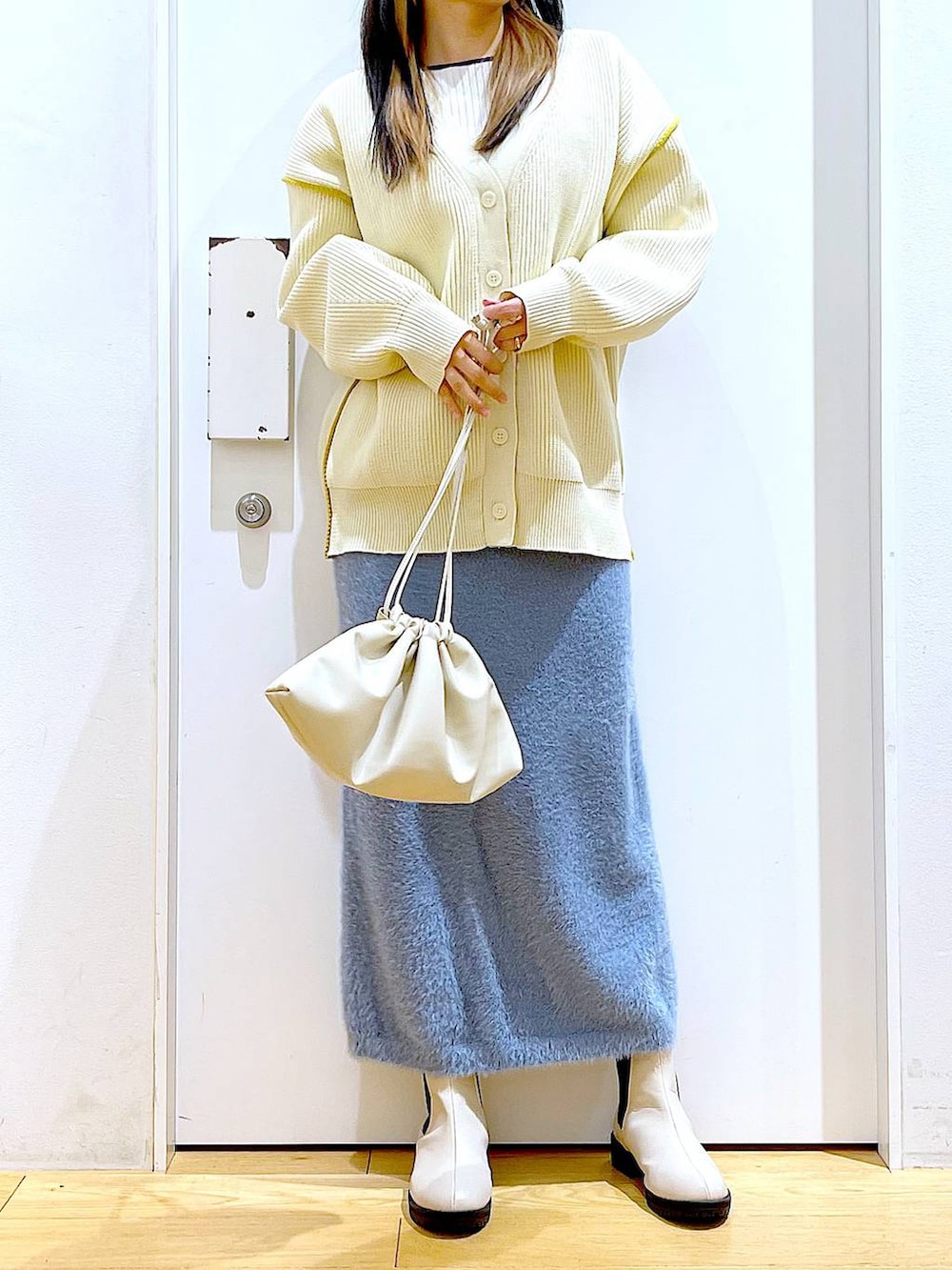 ベージュ系のブーツ、ベージュ系のニット/セーター、ベージュ系のショルダーバッグを着用したレディースの冬コーディネートの6枚目の写真