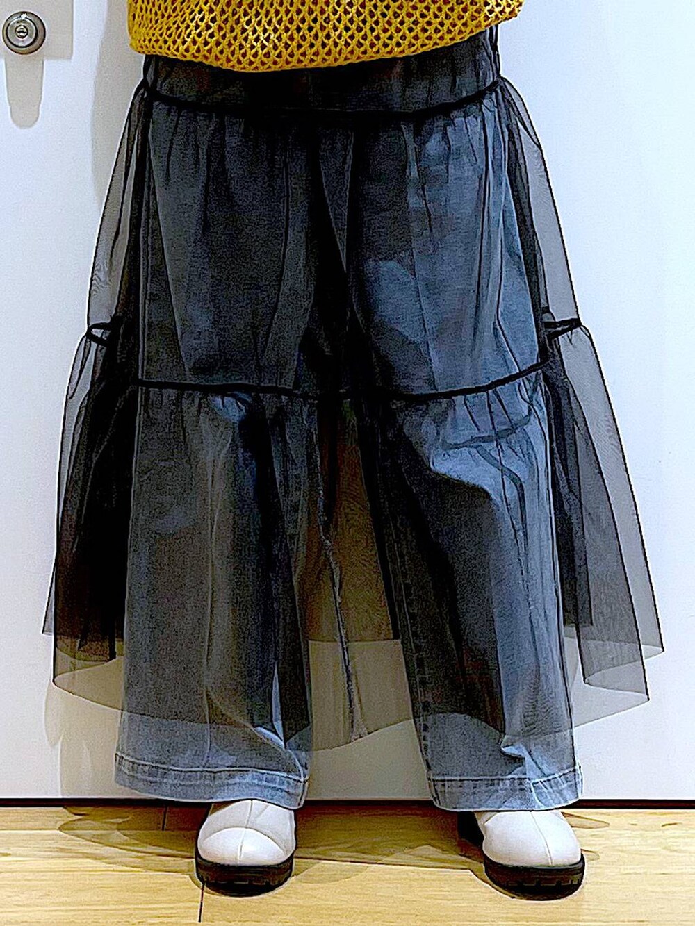 ブルー系のデニムパンツ、ブラック系のTシャツ/カットソー、オレンジ系のニット/セーターを着用したレディースの冬コーディネートの8枚目の写真