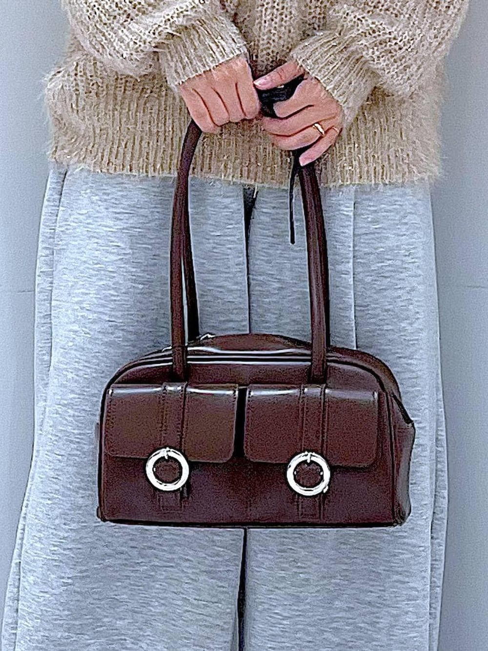 ブラウン系のショルダーバッグ、ブラック系のブーツ、グレー系のスウェットパンツを着用したレディースの冬コーディネートの9枚目の写真