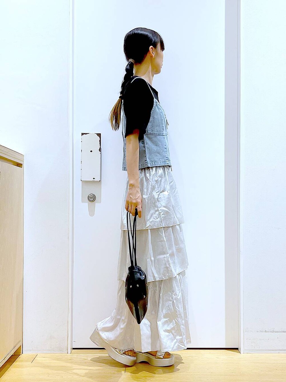 シルバー系のサンダル、ブラック系のショルダーバッグ、ブラック系のTシャツ/カットソーを着用したレディースの夏コーディネートの4枚目の写真