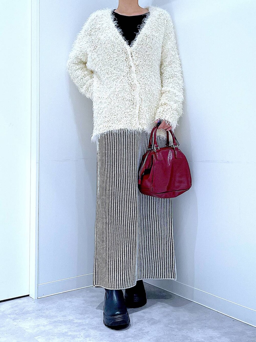 ブラック系のブーツ、ベージュ系のスカート、ベージュ系のカーディガン/ボレロを着用したレディースの秋コーディネートの6枚目の写真