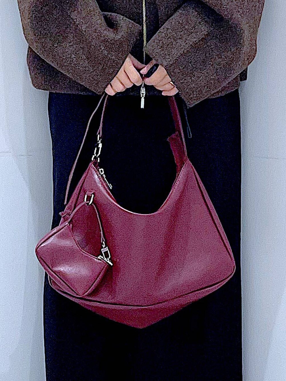 ブラウン系のブルゾン、ブラック系のブーツ、レッド系のショルダーバッグを着用したレディースの秋コーディネートの9枚目の写真