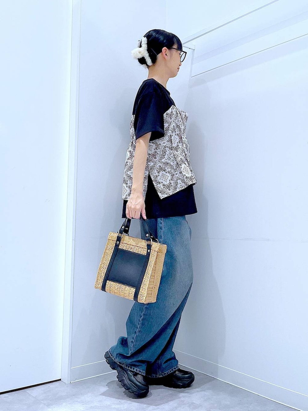 ブルー系のデニムパンツ、ブラック系のスニーカー、ブラック系のTシャツ/カットソーを着用したレディースの春コーディネートの4枚目の写真