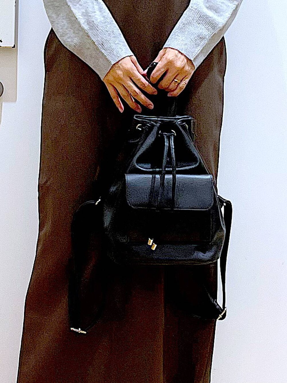 グレー系のニット/セーター、ブラック系のバックパック/リュック、ブラック系のブーツを着用したレディースの冬コーディネートの9枚目の写真