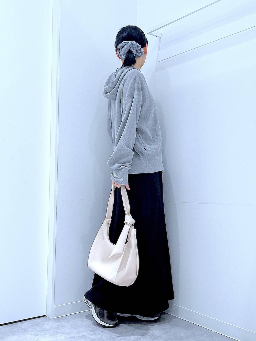 ホワイト系のショルダーバッグ、ブラック系のスカート、グレー系のカーディガン/ボレロを着用したレディースの春コーディネートの4枚目の写真