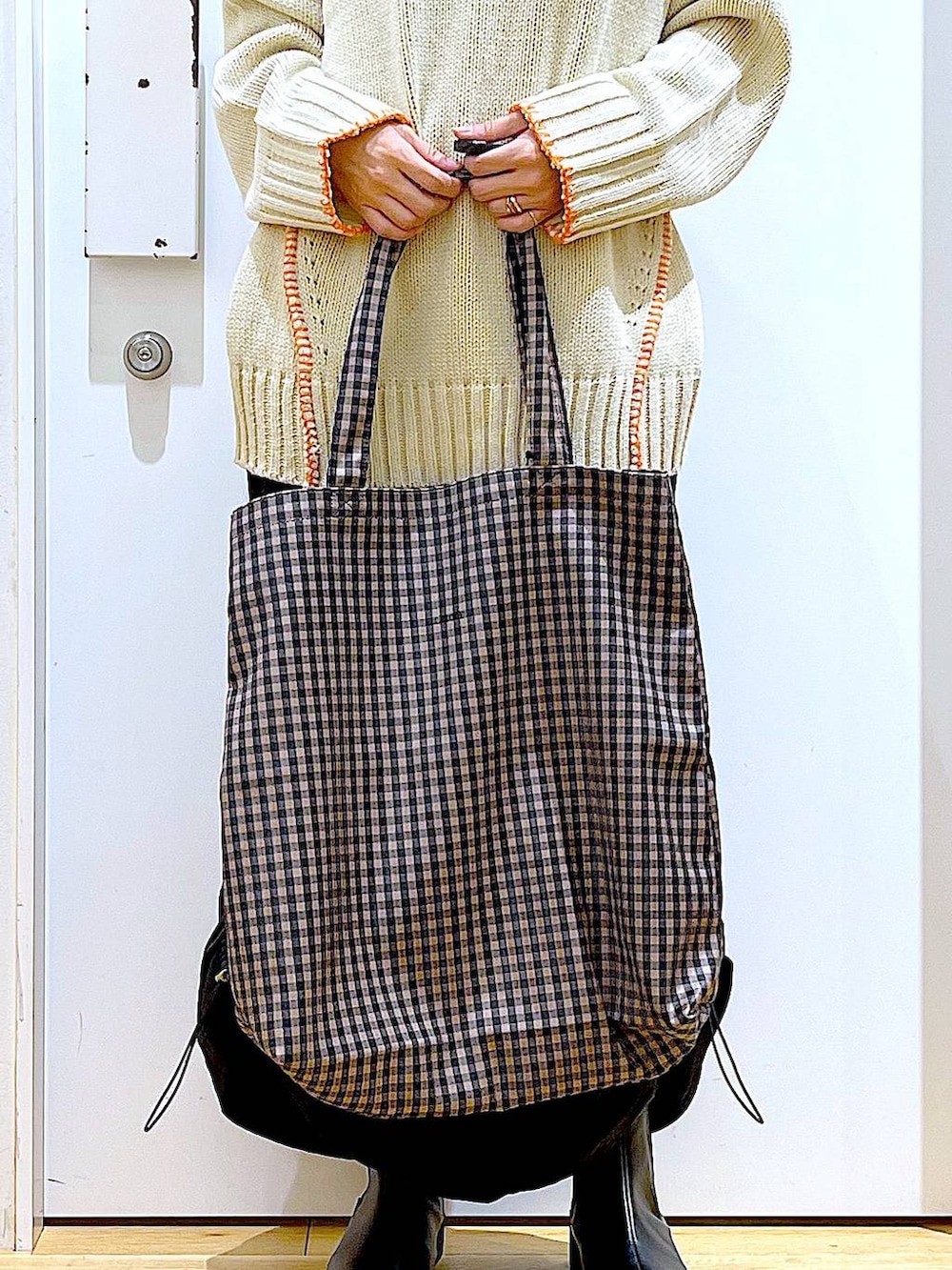 ブラック系のブーツ、その他のトートバッグ、ブラック系のスカートを着用したレディースの冬コーディネートの9枚目の写真