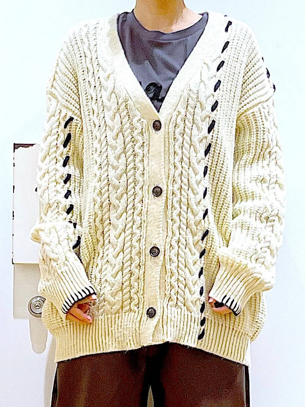 ブラック系のショルダーバッグ、グレー系のTシャツ/カットソー、ブラック系のブーツを着用したレディースの秋コーディネートの7枚目の写真