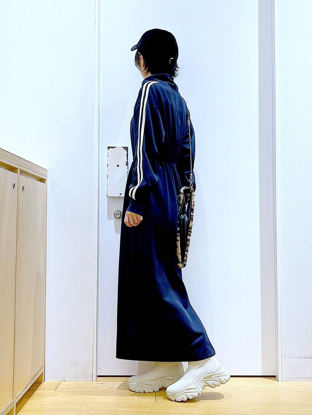 その他のショルダーバッグ、ベージュ系のブーツ、ブルー系のワンピースを着用したレディースの秋コーディネートの3枚目の写真