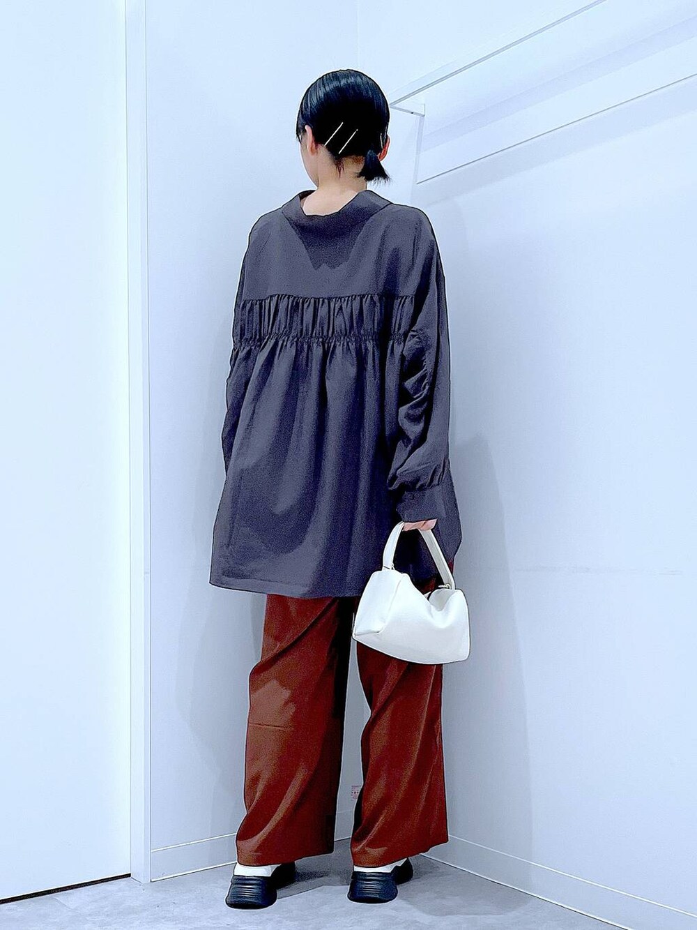 ホワイト系のローファー、ホワイト系のショルダーバッグ、ブラウン系のその他パンツを着用したレディースの秋コーディネートの5枚目の写真