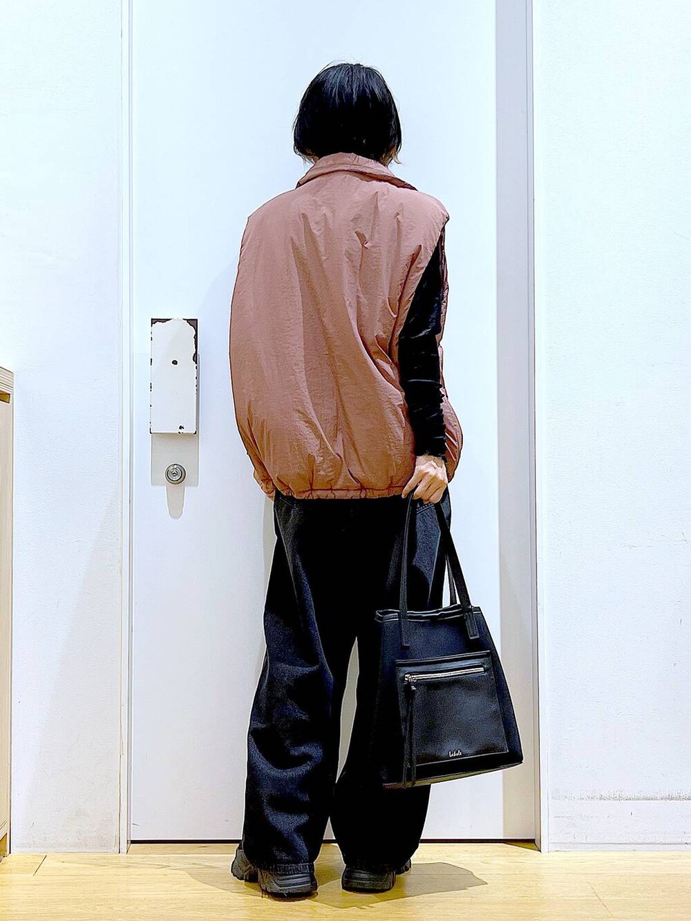 ブラウン系のベスト、ブラック系のトートバッグ、ブラック系のTシャツ/カットソーを着用したレディースの秋コーディネートの5枚目の写真