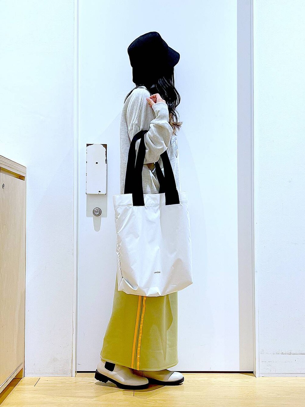 ベージュ系のスウェット、ベージュ系のブーツ、ホワイト系のトートバッグを着用したレディースの冬コーディネートの4枚目の写真