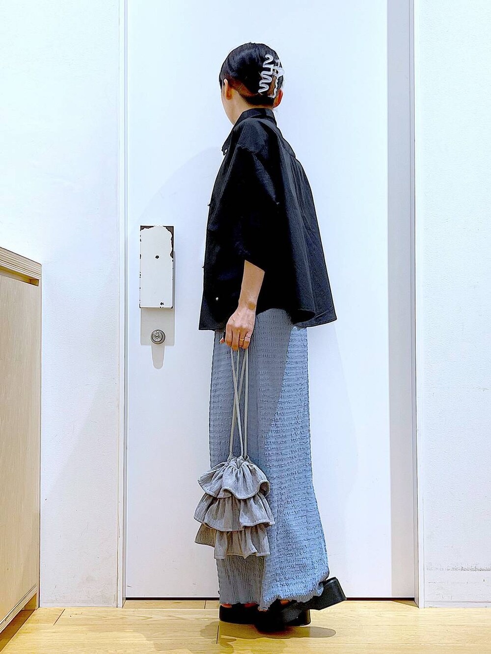 ブラック系のサンダル、ブルー系のスカート、グレー系のショルダーバッグを着用したレディースの秋コーディネートの3枚目の写真