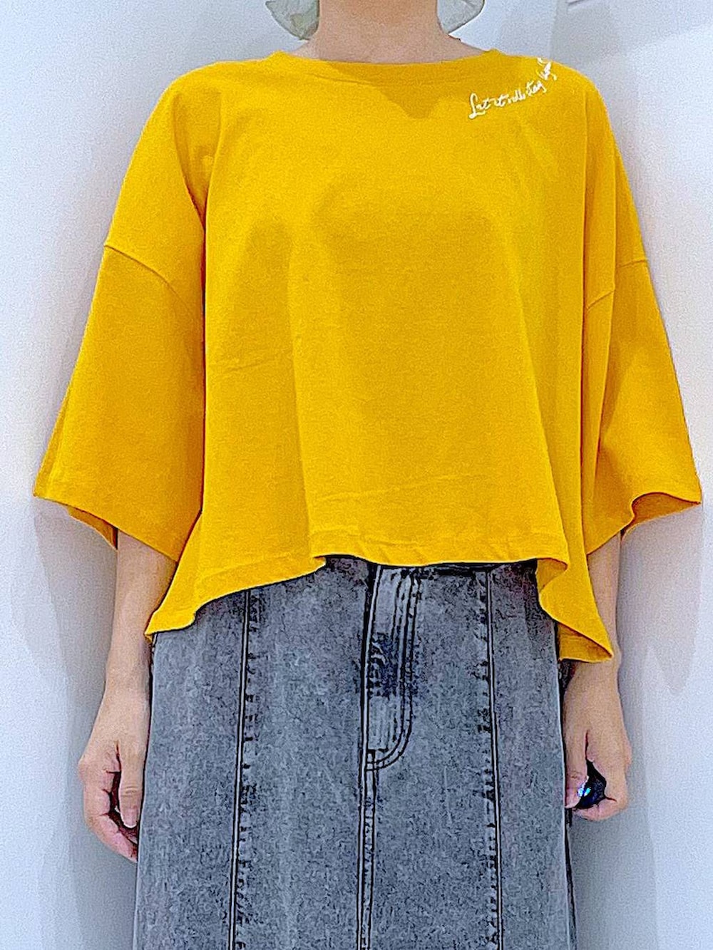 ベージュ系のショルダーバッグ、ブラック系のサンダル、オレンジ系のTシャツ/カットソーを着用したレディースの夏コーディネートの7枚目の写真