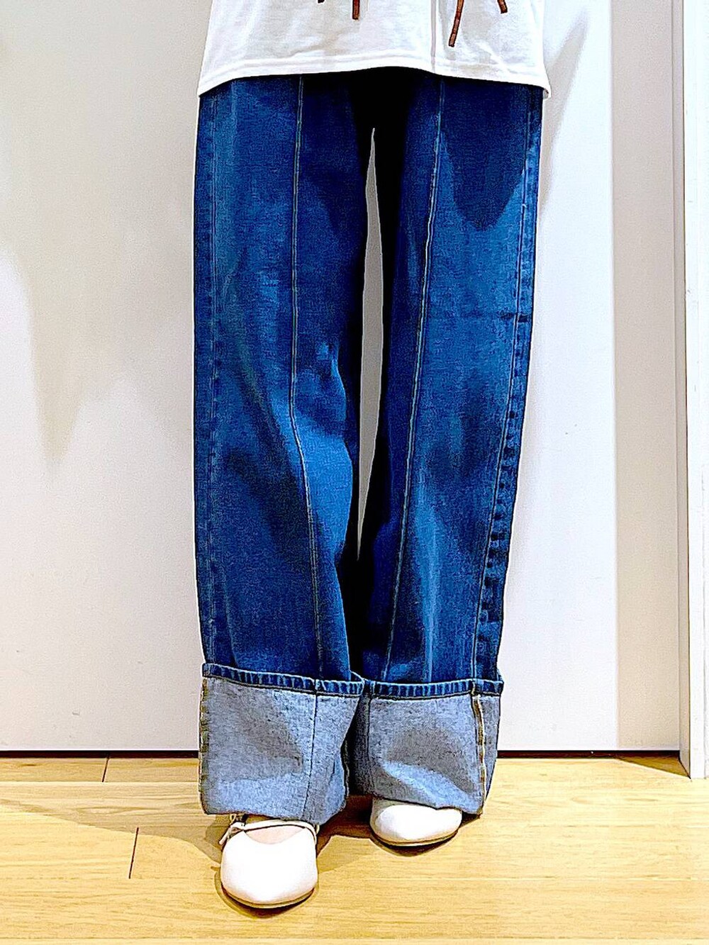 ホワイト系のショルダーバッグ、ホワイト系のパンプス、ブルー系のデニムパンツを着用したレディースの秋コーディネートの8枚目の写真