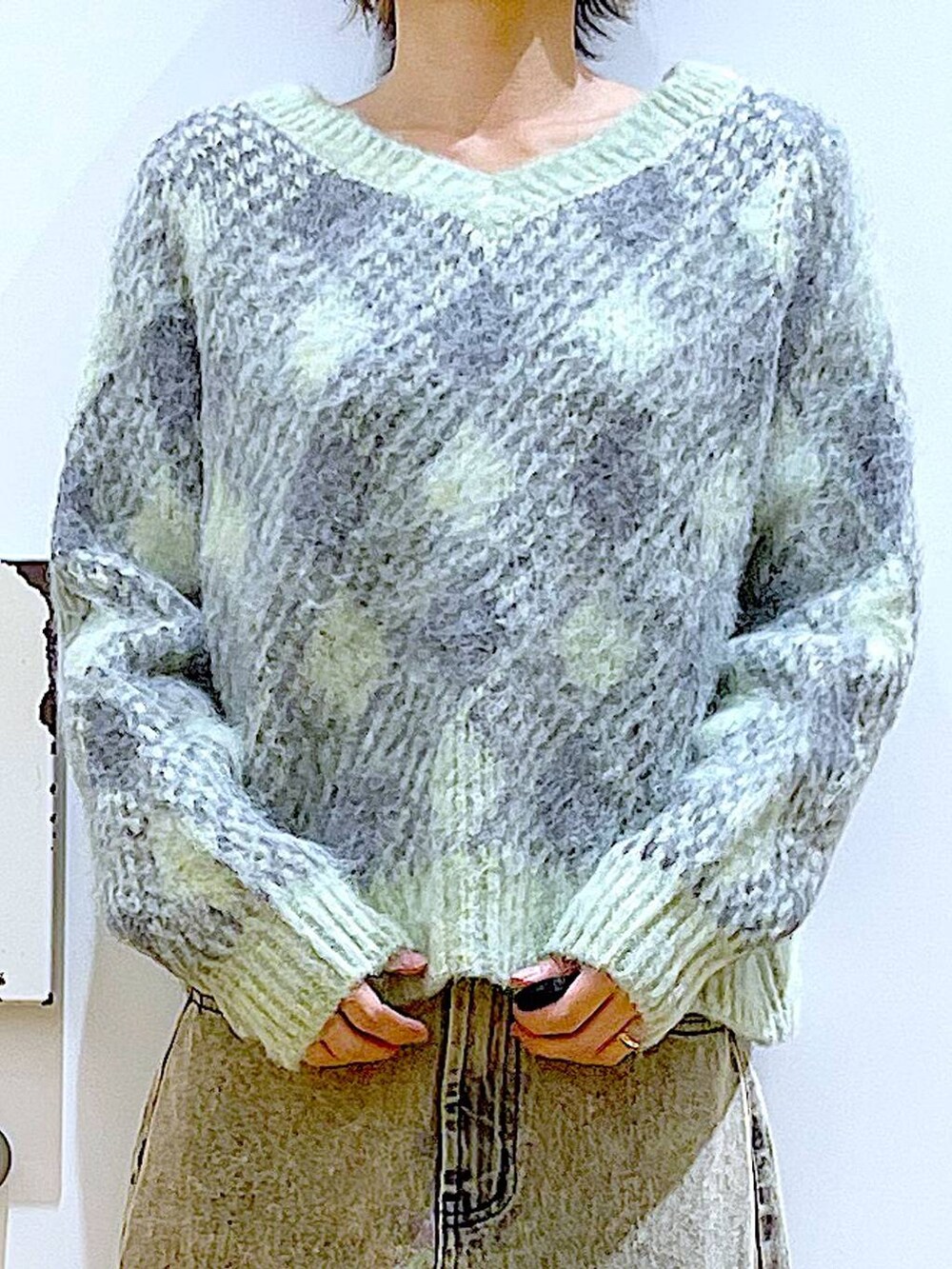 ブラック系のショルダーバッグ、ブラック系のブーツ、ベージュ系のデニムパンツを着用したレディースの冬コーディネートの7枚目の写真