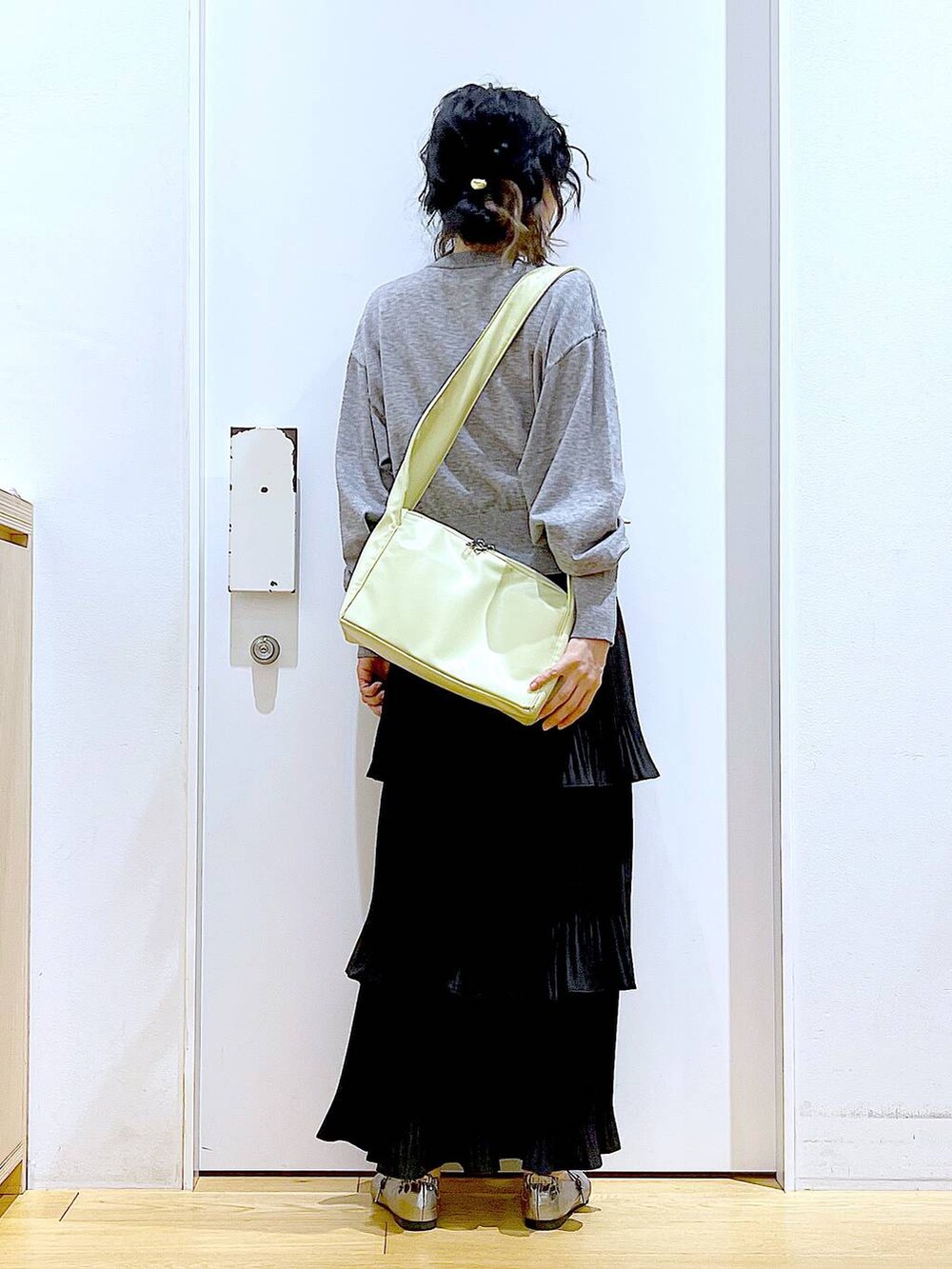 ブラック系のカーディガン/ボレロ、ブラック系のスカート、イエロー系のショルダーバッグを着用したレディースの春コーディネートの5枚目の写真