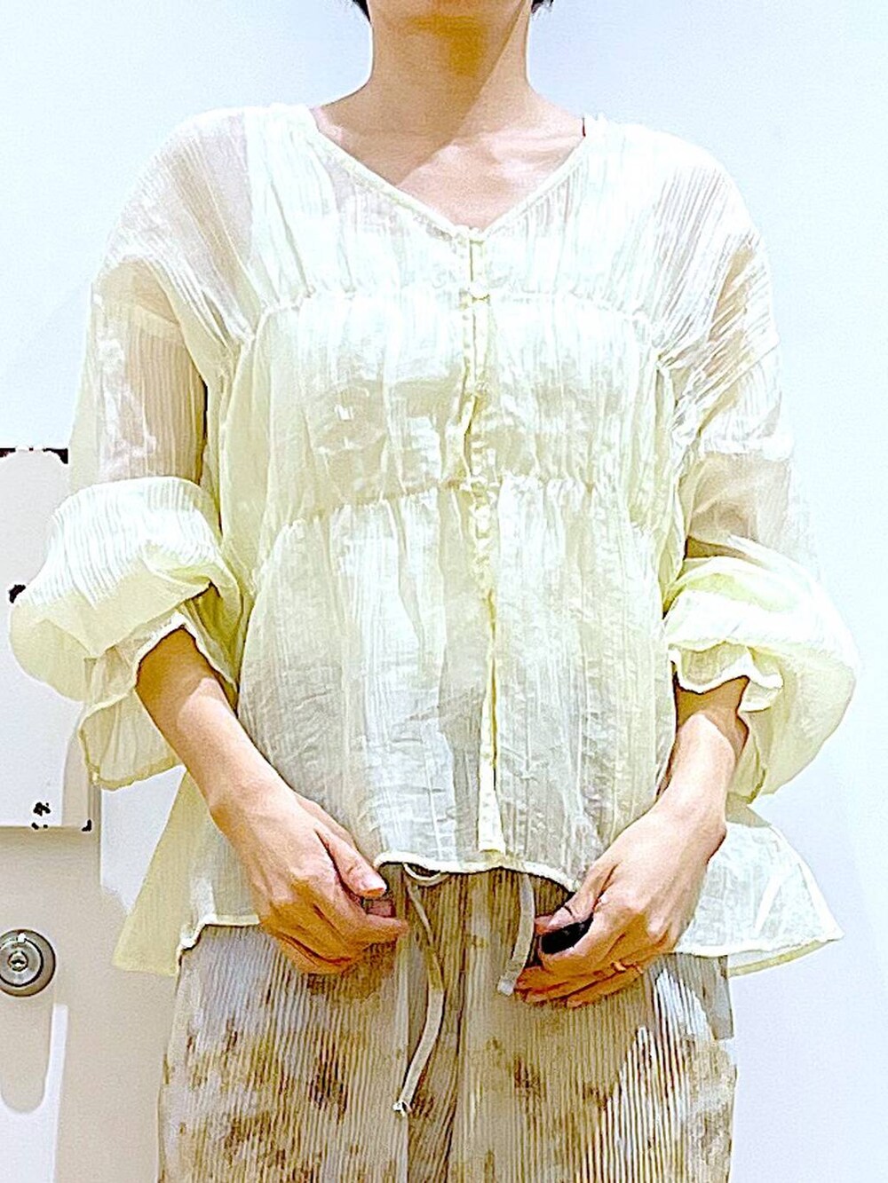 シルバー系のショルダーバッグ、シルバー系のパンプス、ベージュ系のシャツ/ブラウスを着用したレディースの夏コーディネートの7枚目の写真