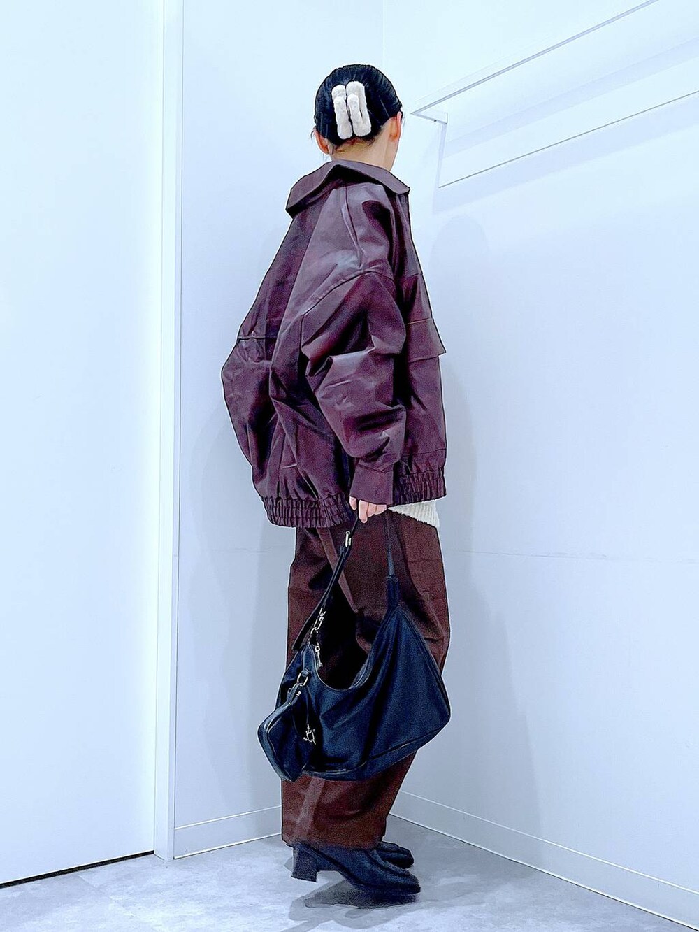 レッド系のブルゾン、ホワイト系のニット/セーター、ブラック系のブーツを着用したレディースの秋コーディネートの4枚目の写真