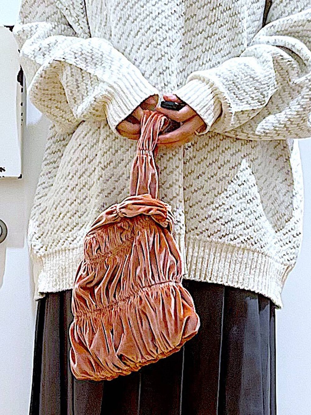 ベージュ系のニット/セーター、ピンク系のショルダーバッグ、ブラック系のブーツを着用したレディースの冬コーディネートの9枚目の写真