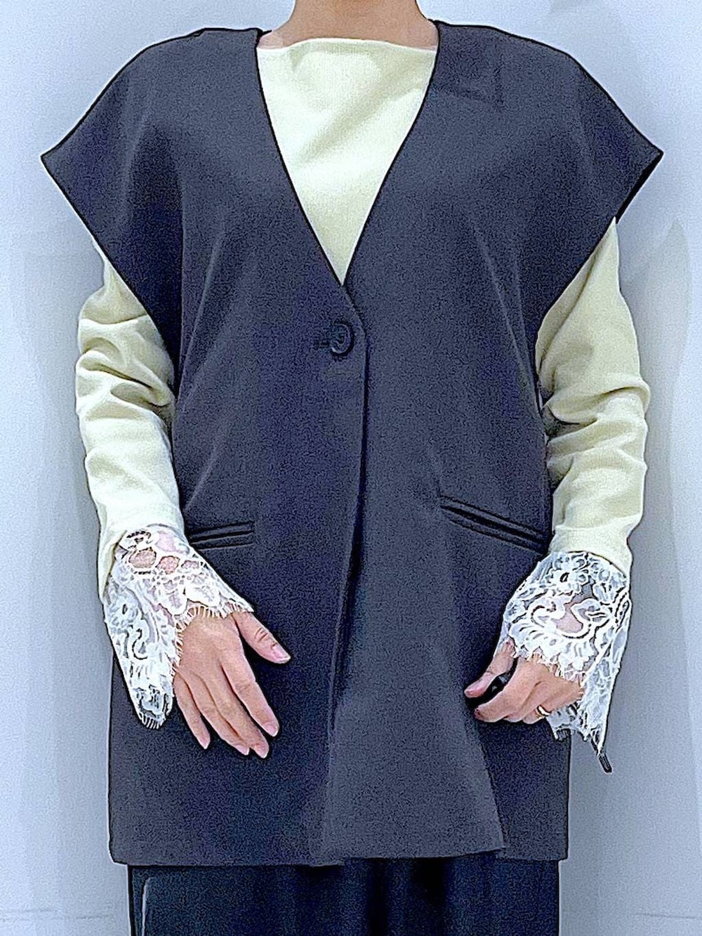 ブラック系のスカート、グレー系のベスト、ブラック系のローファーを着用したレディースの春コーディネートの7枚目の写真