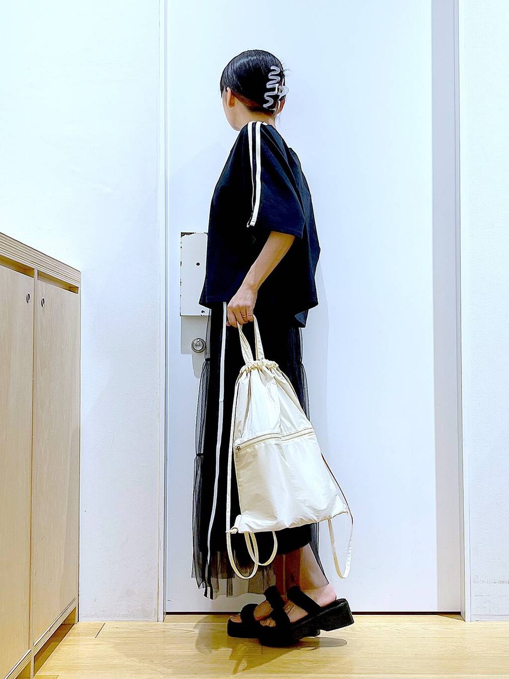 ホワイト系のバックパック/リュック、ブラック系のサンダル、ブラック系のスカートを着用したレディースの夏コーディネートの3枚目の写真