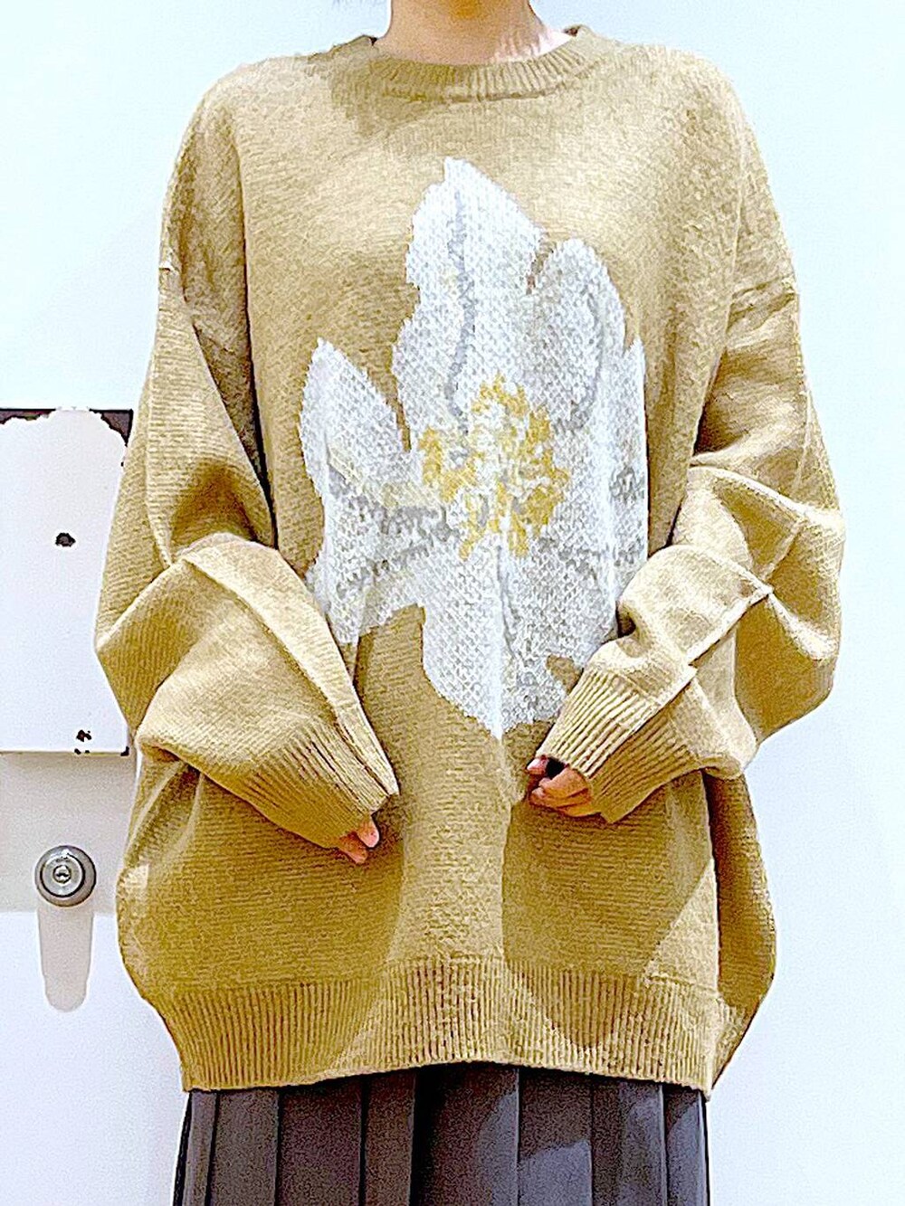 ホワイト系のハンドバッグ、ブラック系のブーツ、グレー系のスカートを着用したレディースの冬コーディネートの7枚目の写真