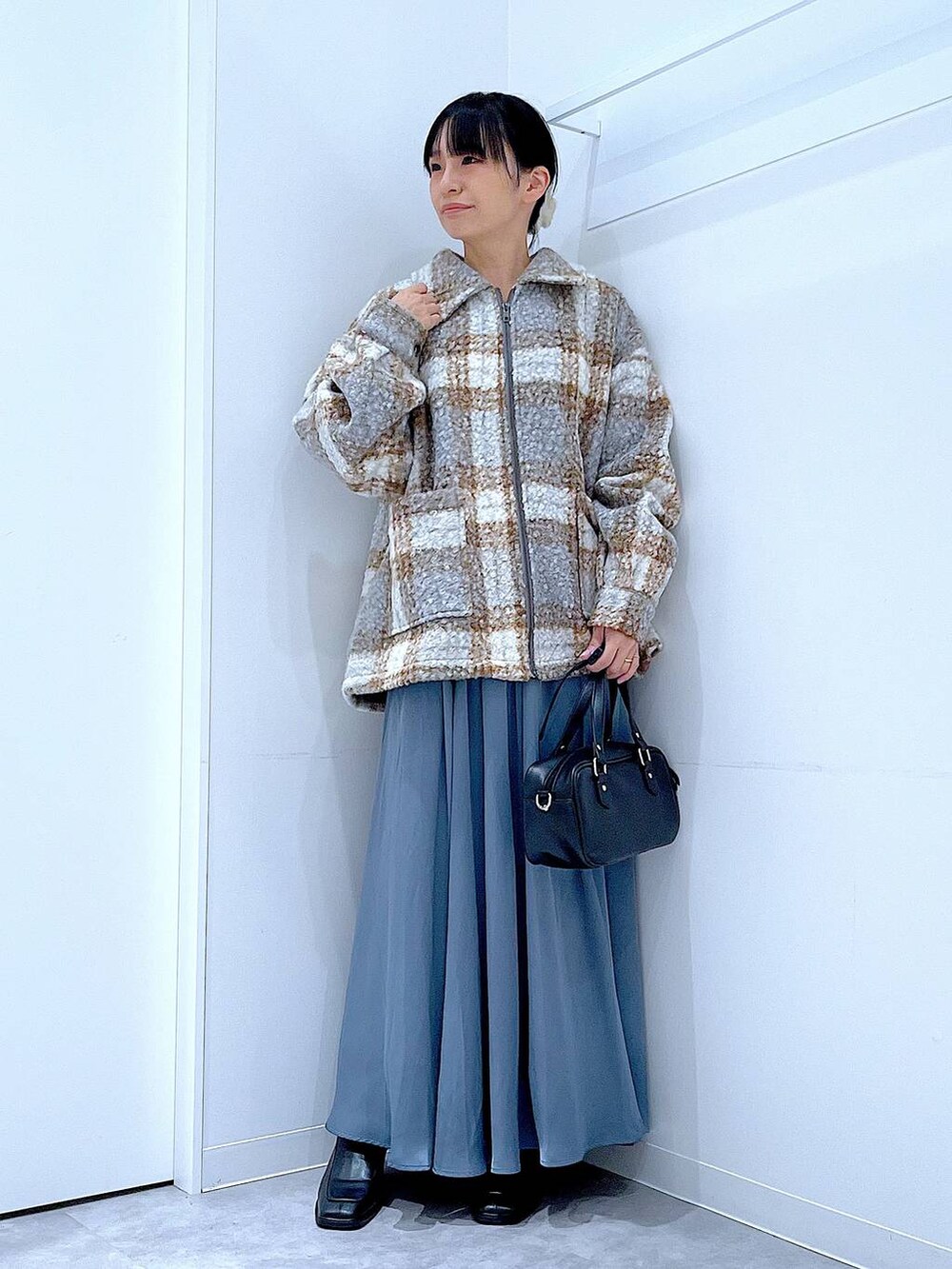 その他のブルゾン、ブラック系のブーツ、ブラック系のショルダーバッグを着用したレディースの秋コーディネートの2枚目の写真