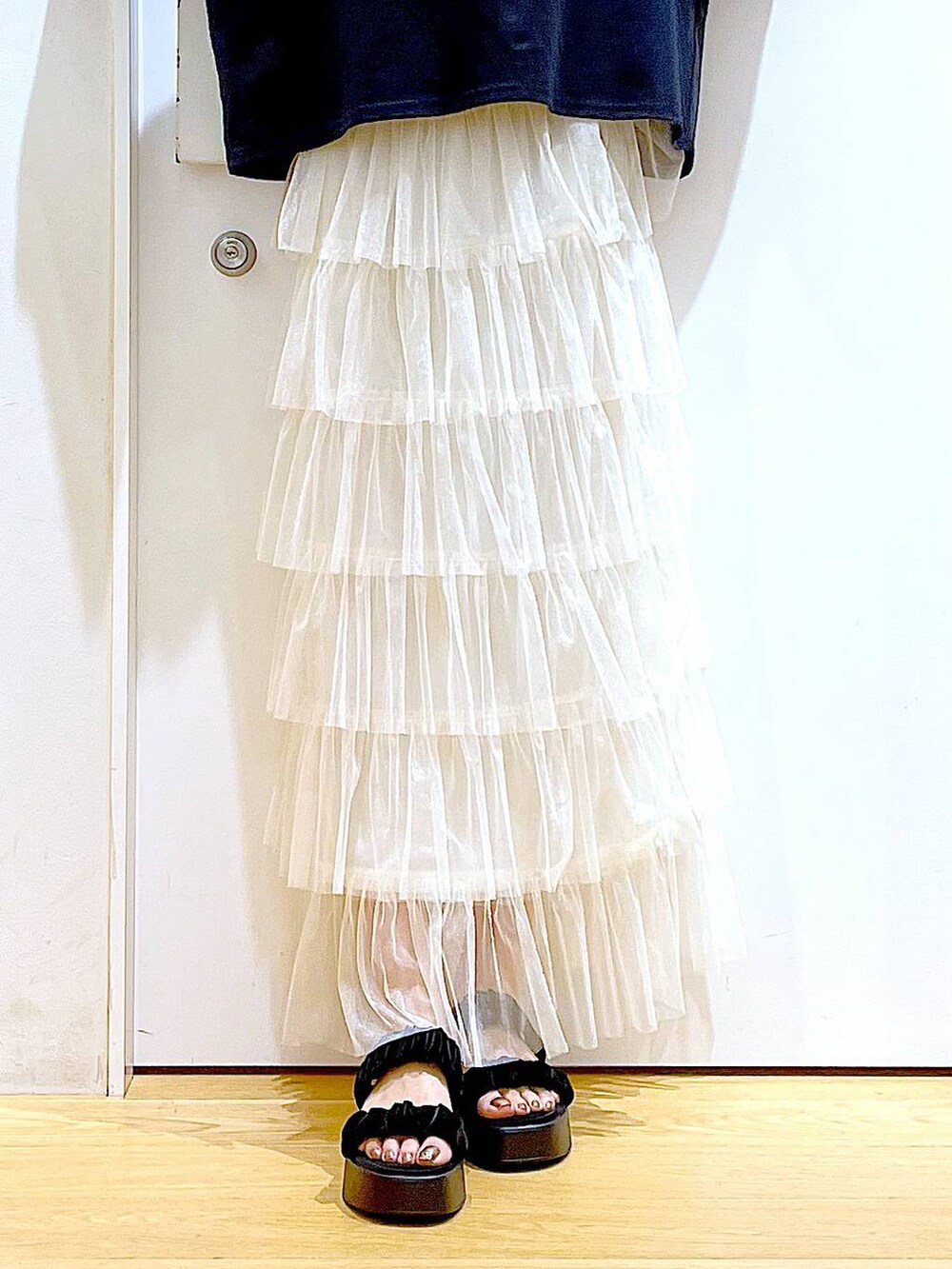 ブラック系のサンダル、ブラック系のショルダーバッグ、ベージュ系のスカートを着用したレディースの夏コーディネートの8枚目の写真