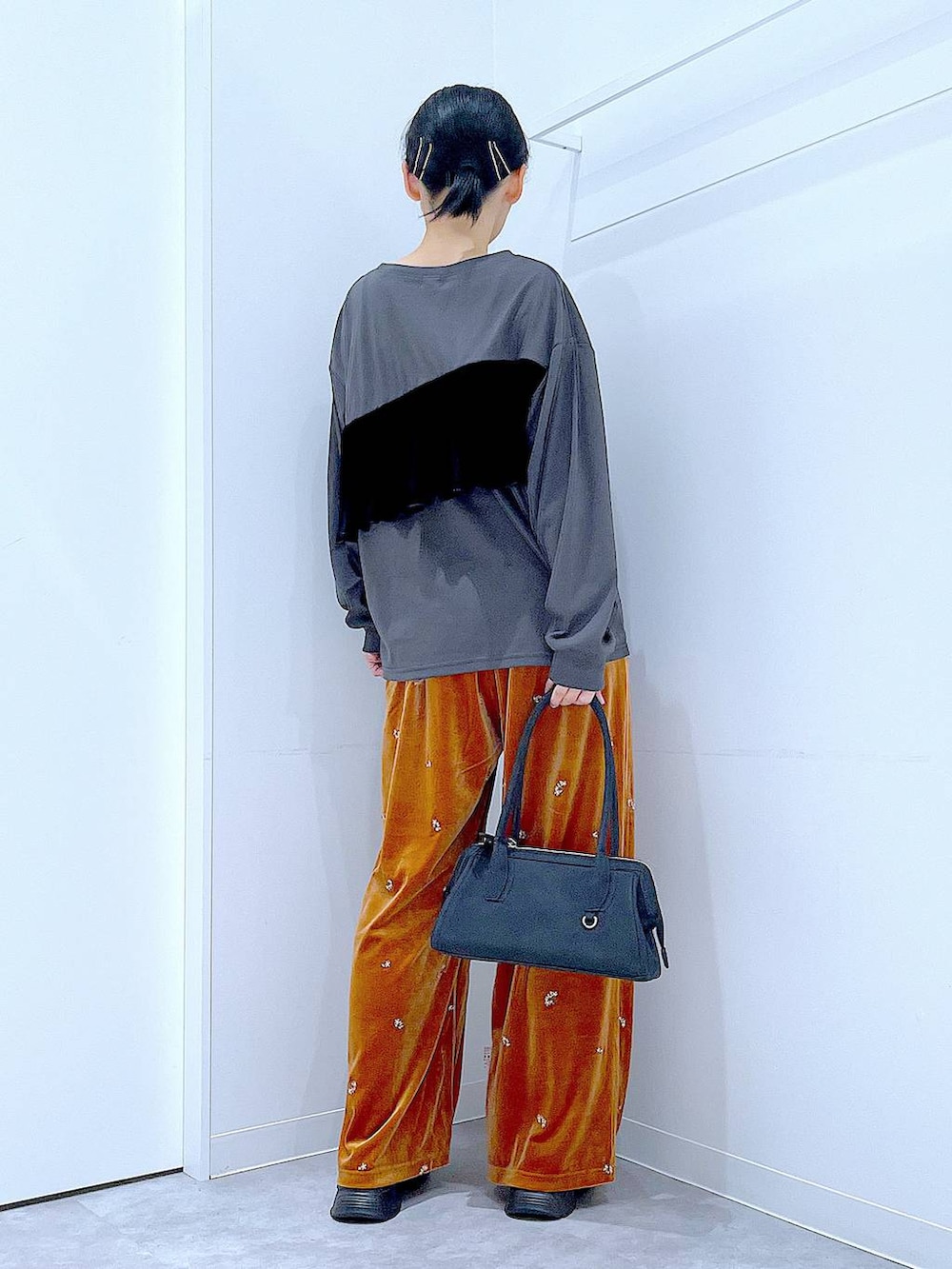 ブラック系のローファー、ブラック系のハンドバッグ、オレンジ系のその他パンツを着用したレディースの秋コーディネートの5枚目の写真