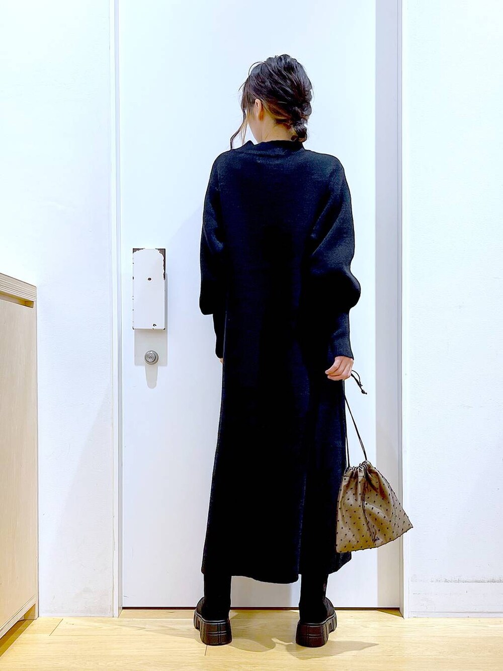 ブラック系のブーツ、ブラック系のワンピース、その他のポーチを着用したレディースの冬コーディネートの5枚目の写真