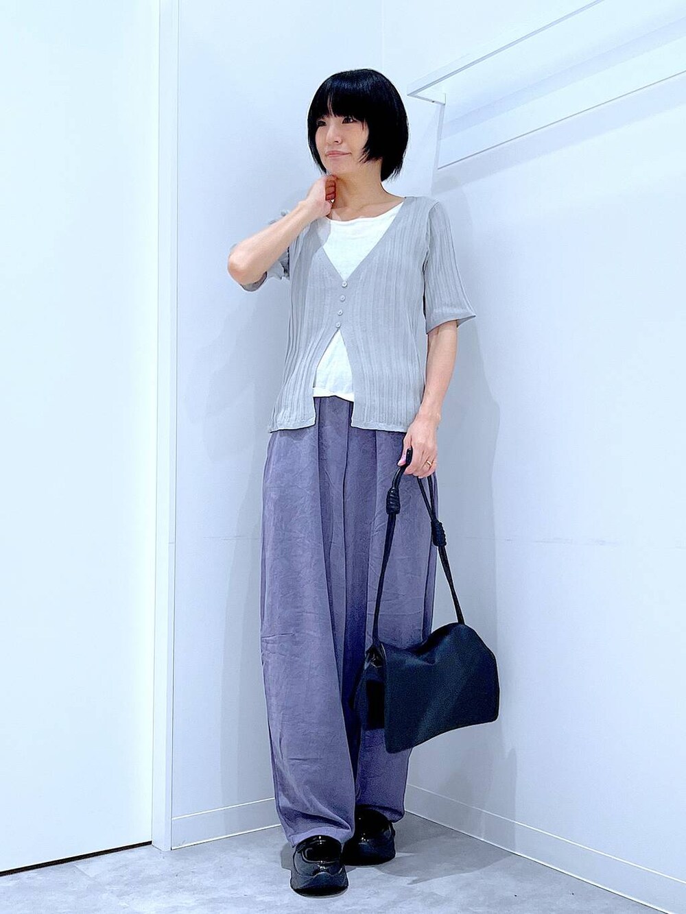 ブラック系のショルダーバッグ、ブラック系のローファー、グレー系のニット/セーターを着用したレディースの秋コーディネートの2枚目の写真