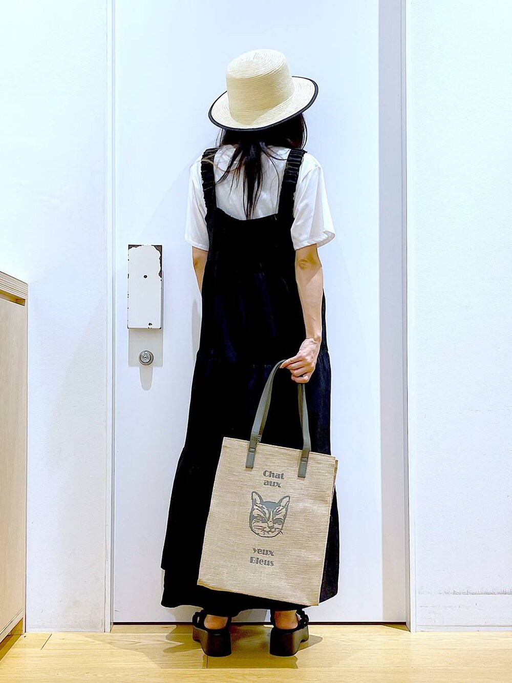ブラック系のサンダル、グレー系のトートバッグ、ホワイト系のTシャツ/カットソーを着用したレディースの夏コーディネートの5枚目の写真